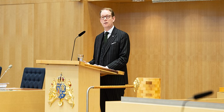Billström står i riksdagens talarstol